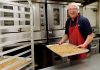 Curtis Moore, owner of Safari Crunch, removes a pan of Cherry Cheetah granola from the oven..jpg