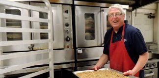 Curtis Moore, owner of Safari Crunch, removes a pan of Cherry Cheetah granola from the oven..jpg